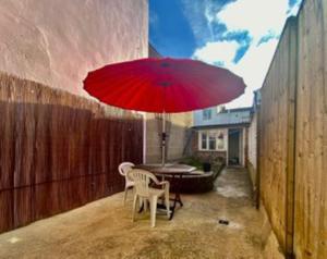 czerwony parasol na patio ze stołem w obiekcie 64 Bath Road - ground floor w mieście Cheltenham