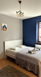 a bedroom with a large bed with a blue wall at Uroczy dom Wszebory 