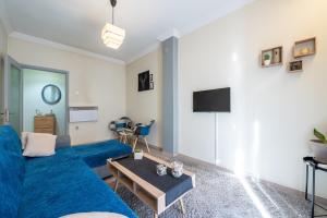 a living room with a blue couch and a table at T’ Giorgio Apartment in Thessaloniki