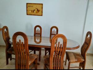 a dining room table with wooden chairs and a table and ahibition at Hospedaje Mérida in San Rafael