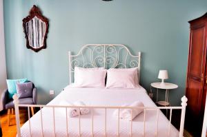 1 dormitorio con cama blanca y pared azul en A Casa do Chafariz, en Ribeira Grande
