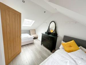 1 dormitorio con cama, tocador y espejo en 2b Seymour road en Hackbridge