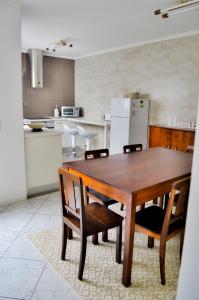 cocina con mesa de madera con sillas y nevera en A Casa do Chafariz, en Ribeira Grande