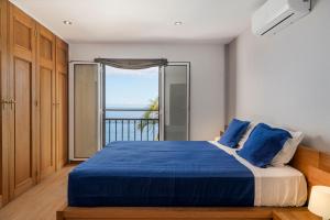 Un dormitorio con una cama azul con vista al mar. en Villa Beach Club, en Santa Cruz