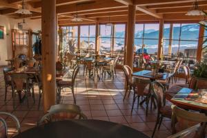a restaurant with tables and chairs with mountains in the background at Almcafe Schnakenhöhe in Maria Rain