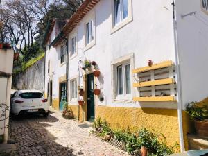 a small street with a white car parked next to a building at Pé do Castelo Casinha in Tomar