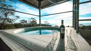 uma garrafa de vinho sentada numa mesa ao lado de uma piscina em Villa Ometepe em Mérida