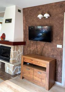 sala de estar con TV y chimenea de piedra en Uroczy dom Wszebory 