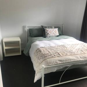 a bedroom with a bed and a night stand at Unit 1 - Manly Boutique Apartments in Brisbane