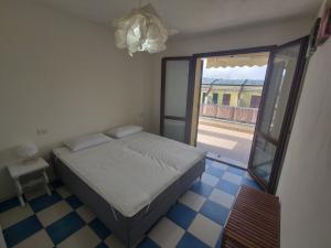 una camera con letto e porta scorrevole in vetro di Appartamento L'Azalea - a due passi da Numana con grande terrazzo e piscina condominiale stagionale a Sirolo
