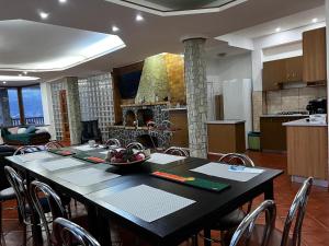 comedor y cocina con mesa y sillas en Infinity Villa en Buşteni