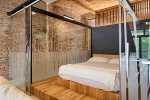 een slaapkamer met een bed en een bakstenen muur bij CAN JAUME 1921 Plaza Perpinyà ,21 in Banyoles