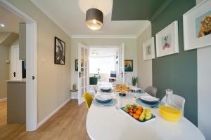 a dining room with a white table with fruit on it at Stunning luxury 3 bed house with garden in North Leeds in Moortown