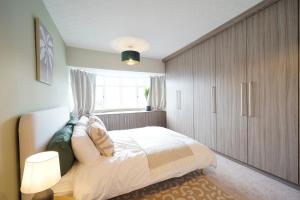 ein Schlafzimmer mit großem Bett und Fenster in der Unterkunft Stunning luxury 3 bed house with garden in North Leeds in Moortown