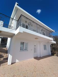 Cette maison blanche dispose d'un balcon. dans l'établissement Apartments Sea View, à Bar