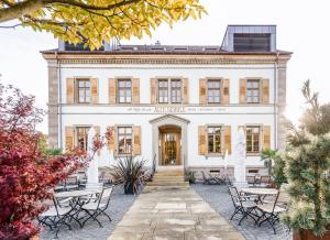 un edificio con mesas y sillas delante de él en Alte Schule Tiefenbach, en Tiefenbach