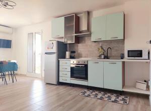 a kitchen with white cabinets and a refrigerator at Terrazza 44 in Lecce