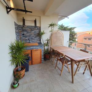 a patio with a wooden table and chairs on a balcony at Giancasavacanze in Alghero