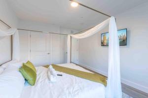 una camera con un letto bianco a baldacchino di 2 bedroom 2 bath Suite, Near American Dream and The Airport, Free Parking, King Bed and 2 Queen Beds, Washer and Dryer a Orange