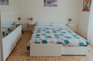 a bedroom with a bed with a blue and white quilt at La casa di Grazia in Rome