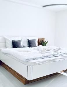 Una cama blanca con sábanas blancas y almohadas. en Luxe Apartments, en Ljutomer