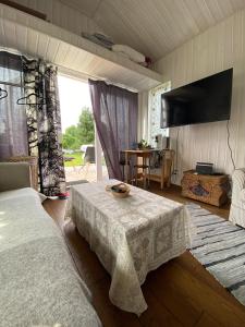 a bedroom with a bed and a table and a television at Elo Külalismaja in Kuressaare