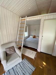 a bedroom with a bunk bed and a ladder and a chair at Elo Külalismaja in Kuressaare