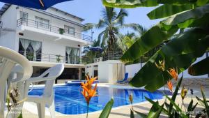 a villa with a swimming pool in front of a house at CASA VACACIONAL CAMPOSOL in Melgar