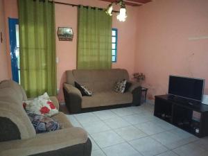 a living room with a couch and a flat screen tv at Sítio Descanso E Natureza Igarapé - 20km Inhotim in Igarapé