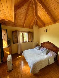Un dormitorio con una cama grande en una habitación con techos de madera. en Floral garden house en Icod de los Vinos