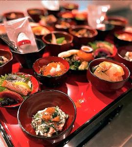 Ein Haufen Schüsseln mit Essen auf einem roten Tablett. in der Unterkunft Aizuwakamatsu - House - Vacation STAY 94546v in Aizu-Wakamatsu