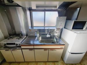 een kleine keuken met een wastafel en een koelkast bij Corp Temma - Vacation STAY 08268v in Takayama