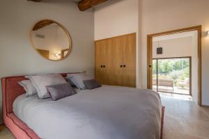 a bedroom with a large bed with a mirror on the wall at Bastidon du Domaine de La Julienne in Tourves