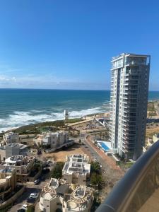 a view of the ocean and a tall building at Exclusive view ocean in Natanya the sea promenade in Netanya