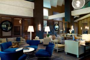 a lobby with blue chairs and couches and tables at Le Meridien Delfina Santa Monica in Los Angeles