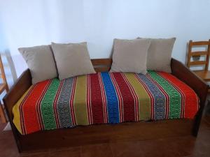 a bed with two pillows and a colorful blanket at Casa do Celeiro - Monsaraz in Monsaraz