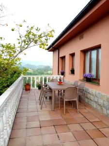 patio con mesa y sillas en el balcón en Casa Nieves, en Villaviciosa