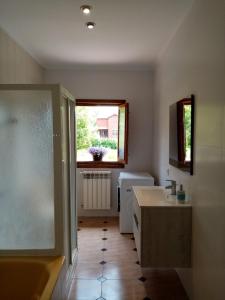 baño con bañera, lavabo y ventana en Casa Nieves en Villaviciosa