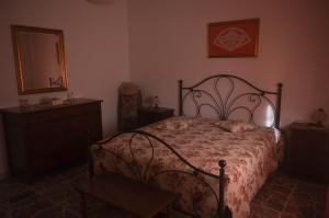 una camera con letto, cassettiera e specchio di Casa della Nonna a Piombino