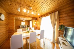une salle à manger avec une table blanche et des chaises blanches dans l'établissement Awaji Large Loghouse in Goshiki - Vacation STAY 64354v, à Sumoto