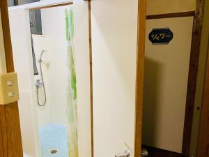 La salle de bains est pourvue d'une douche avec une porte en verre. dans l'établissement Ishigakijima no Sudomari Orihimeno Yado - Vacation STAY 68049v, à Ishigaki