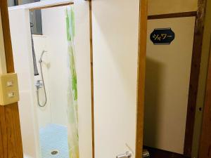 une salle de bain avec une douche avec une porte vitrée dans l'établissement Ishigakijima no Sudomari Orihimeno Yado - Vacation STAY 72074v, à Ishigaki