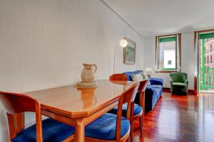 a dining room with a table and chairs and a couch at Luminoso apartamento en el centro de Hondarribia in Hondarribia