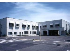 an empty parking lot in front of a white building at Mashu Onsen Hotel Mashu - Vacation STAY 69295v in Teshikaga