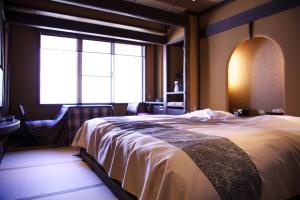 um quarto com uma cama grande e uma janela em Nakaya Ryokan em Minakami