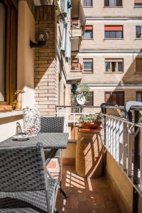 een patio met een tafel en stoelen op een balkon bij Casa 3 Santi, your contemporary home in Rome in Rome