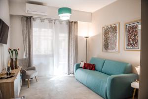 een woonkamer met een blauwe bank en een raam bij Casa 3 Santi, your contemporary home in Rome in Rome