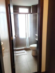 a bathroom with a toilet and a window at Lovely 2B-2B Condo in the best area of Cuenca. in Cuenca