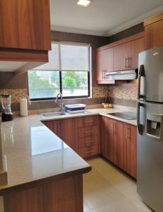 a kitchen with wooden cabinets and a stainless steel refrigerator at Lovely 2B-2B Condo in the best area of Cuenca. in Cuenca