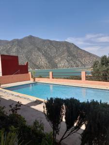 a swimming pool with a mountain in the background at Riad Diwane in Ouirgane
